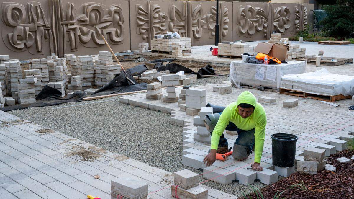 Construction workers lay bricks for a sidewalk in downtown Sacramento on in November 2022. California’s unemployment rate was the nation’s highest in February, attributed to high cost of living and loss of construction, machinery and agriculture jobs.