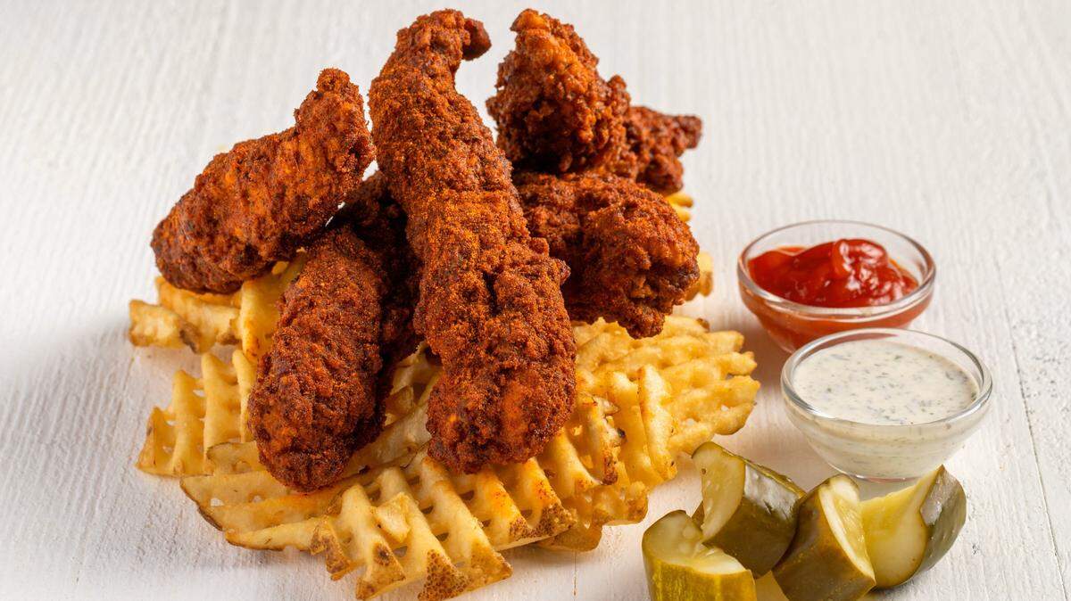 Bruxie’s jumbo tenders and waffle fries are served with dipping sauces and chopped pickles.