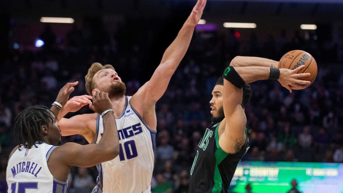 Boston Celtics forward Jayson Tatum is guarded by Sacramento Kings forward Domantas Sabonis (10) during the second half of an NBA basketball game in Sacramento, Calif., Friday, March 18, 2022. The Celtics won 126-97. (AP Photo/Randall Benton)