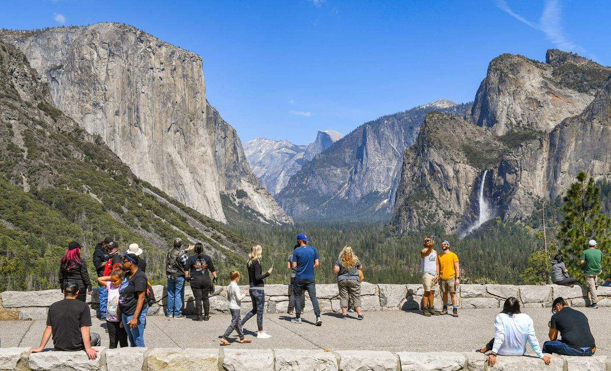 Visitors take in the splendor of the Yosemite Valley in spring at the popular Tunnel View scenic vista in Yosemite National Park on Friday, April 23, 2021.