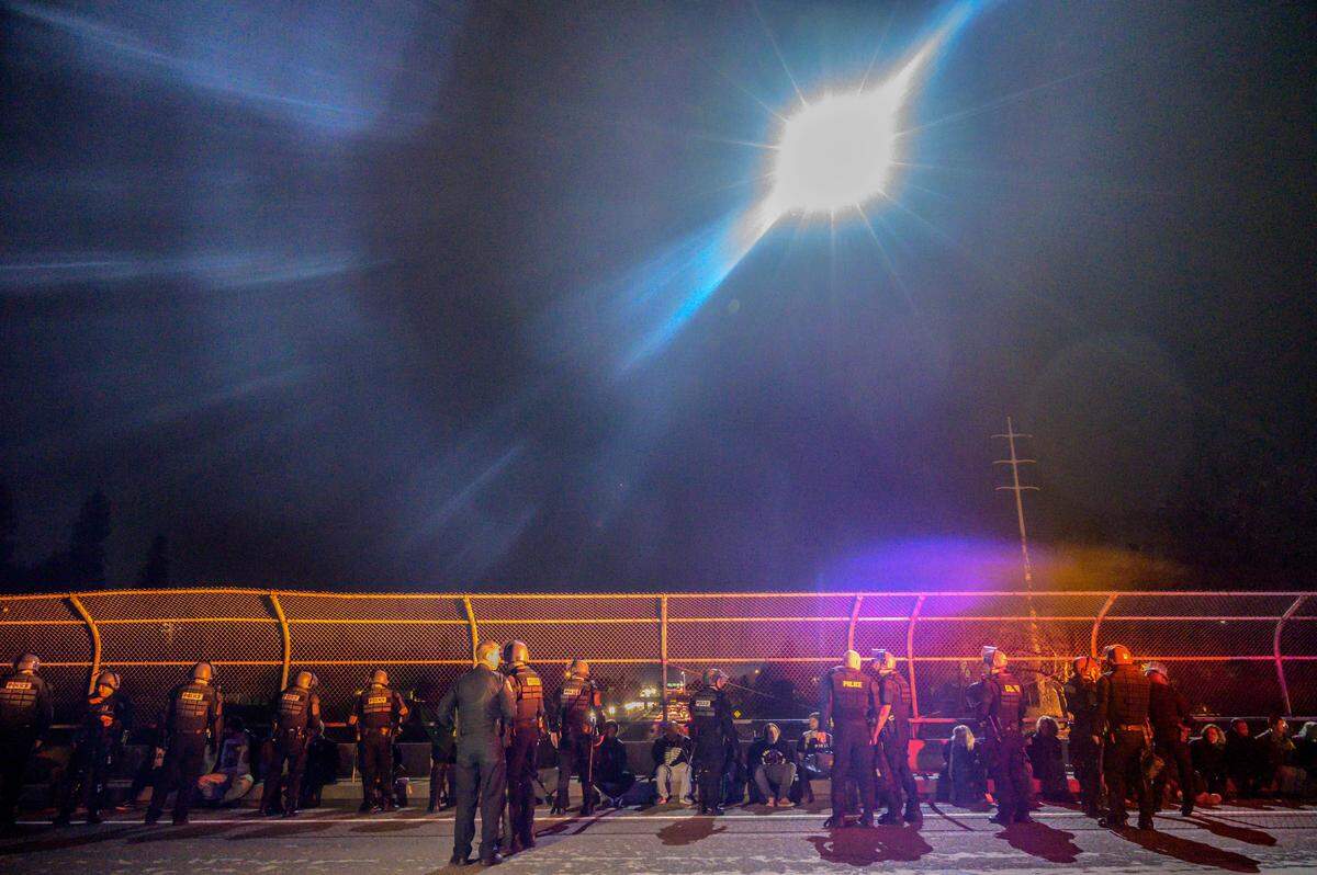 Protesters from a Stephon Clark march in East Sacramento are arrested on Monday on the 51st Street bridge over Highway 50 as a police helicopter illuminates the scene.