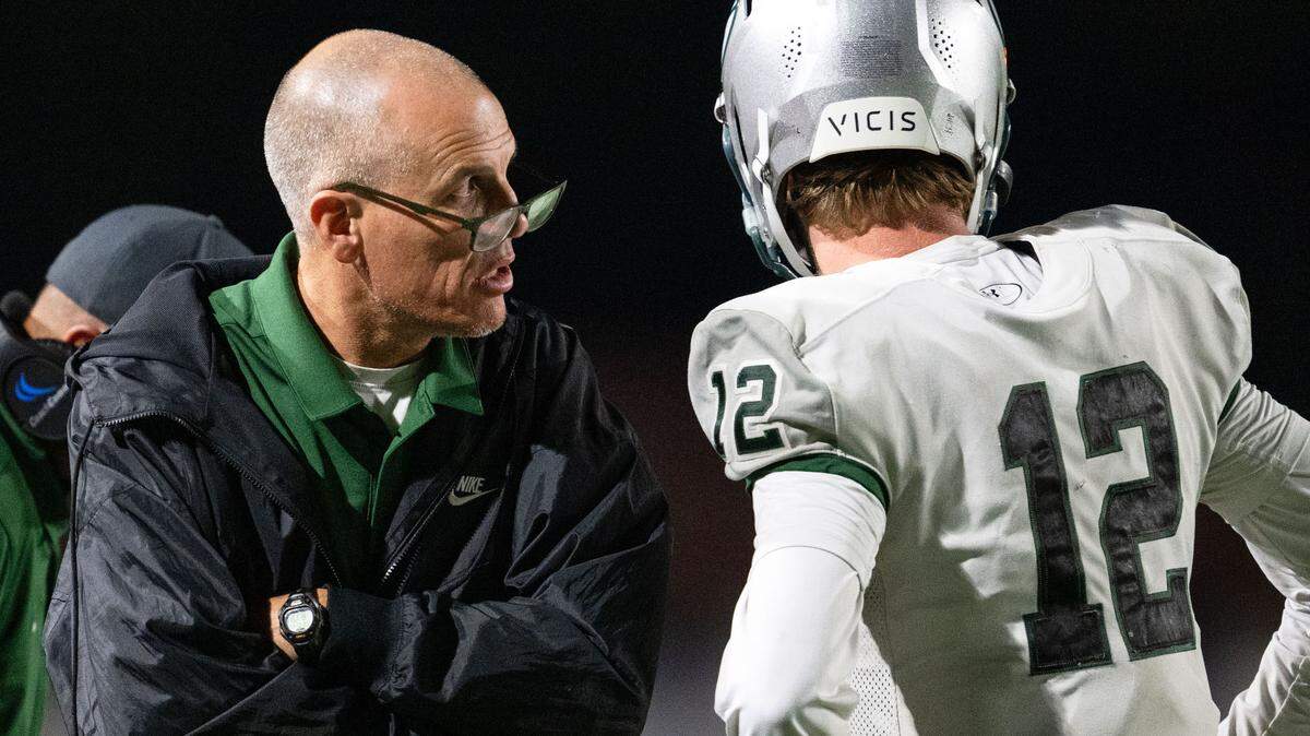 Granite Bay coach Joe Cattolico consults with Granite Bay Grizzlies quarterback Nick Harris (12) during a game against Rocklin in 2024. Cattolico recently won his 200th game as a high school football coach.