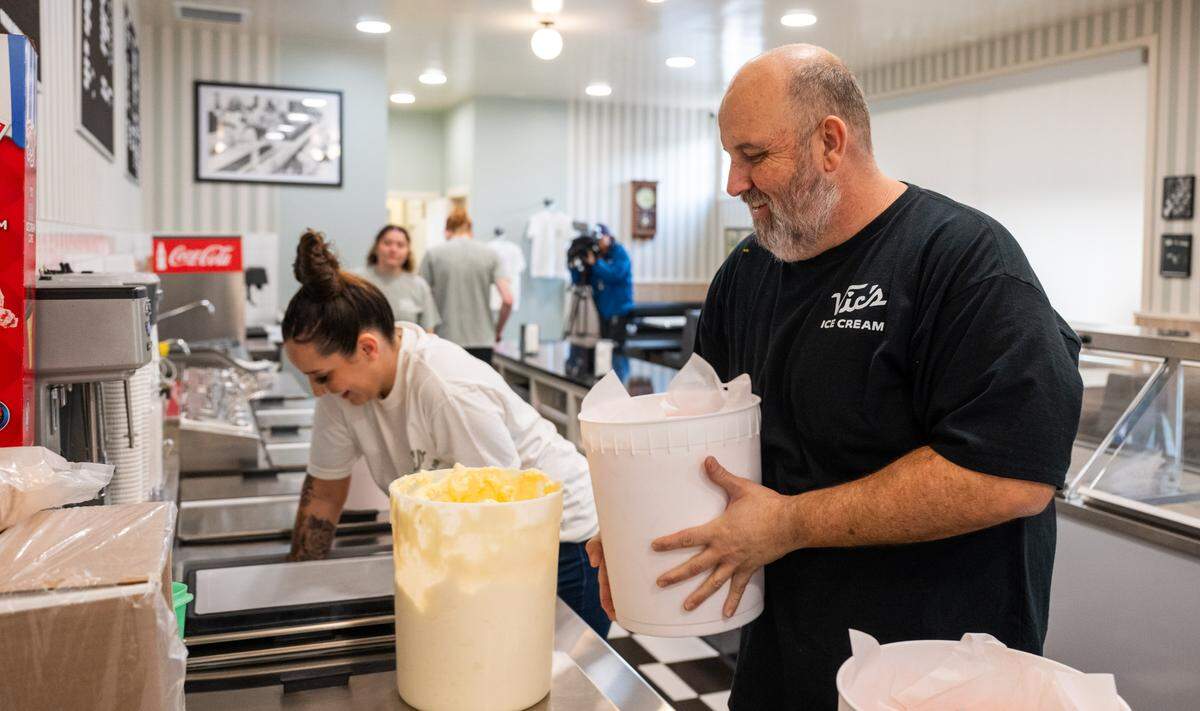 General manager Dave Gilson moves ice cream tubs into position before the reopening of Vic’s Ice Cream in Sacramento on Saturday.