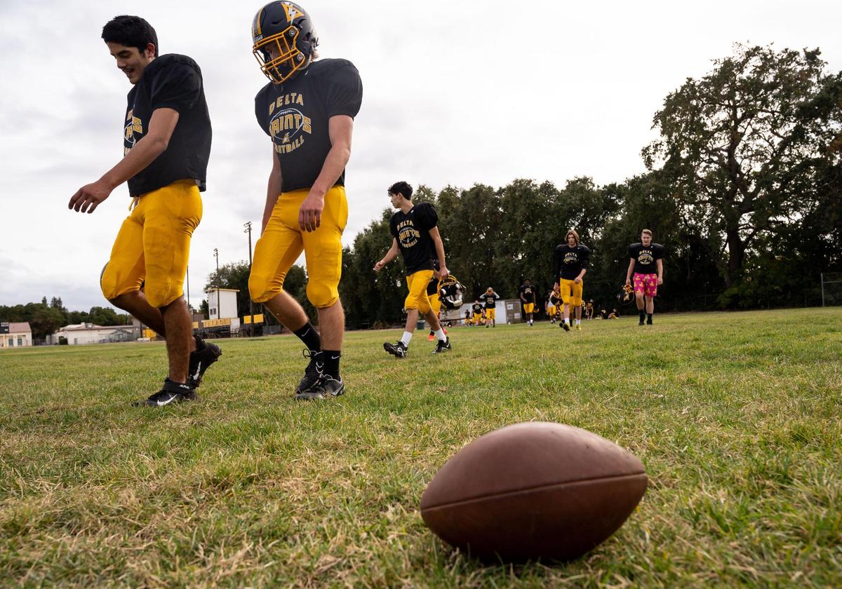 Delta High School football players Devoyn Corzantes, left, 17, and Zachary Carli, 16, both of Walnut Grove, walk back to practice after a water break Wednesday, Oct. 20, 2021, in Clarksburg.
