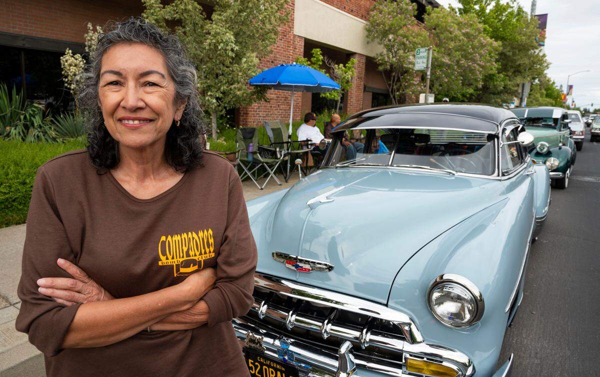 Olivia Fonseca stands by her light blue 1952 Chevrolet Deluxe on Saturday during a lowrider event on Broadway. She is a member of the Sacramento Lowrider Commission that helped urge the city to repeal its 34-year anti-cruising ordinance.