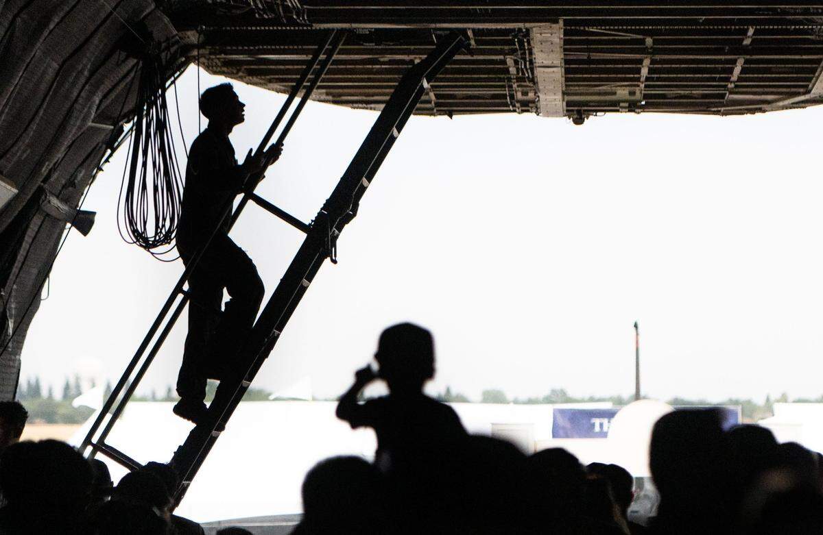 A U.S. Air Force member climbs up a ladder in a Lockheed C-5 Galaxy during the California Capital Airshow at Mather Airport near Rancho Cordova on Saturday, July 13, 2024. “In the air, probably the favorite moment is just being with the crew,” aircraft commander Travis Cratty said. “You know, you have that one running joke that goes along for an entire mission. That’s always fun.”