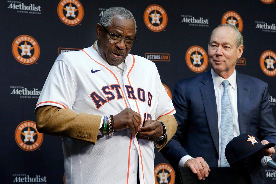 Dusty Baker, left, puts on an Astros jersey next to team owner Jim Crane, right, during a press conference where Baker was formally announced as the new Astros manager at Minute Maid Park in January 2020 in Houston.