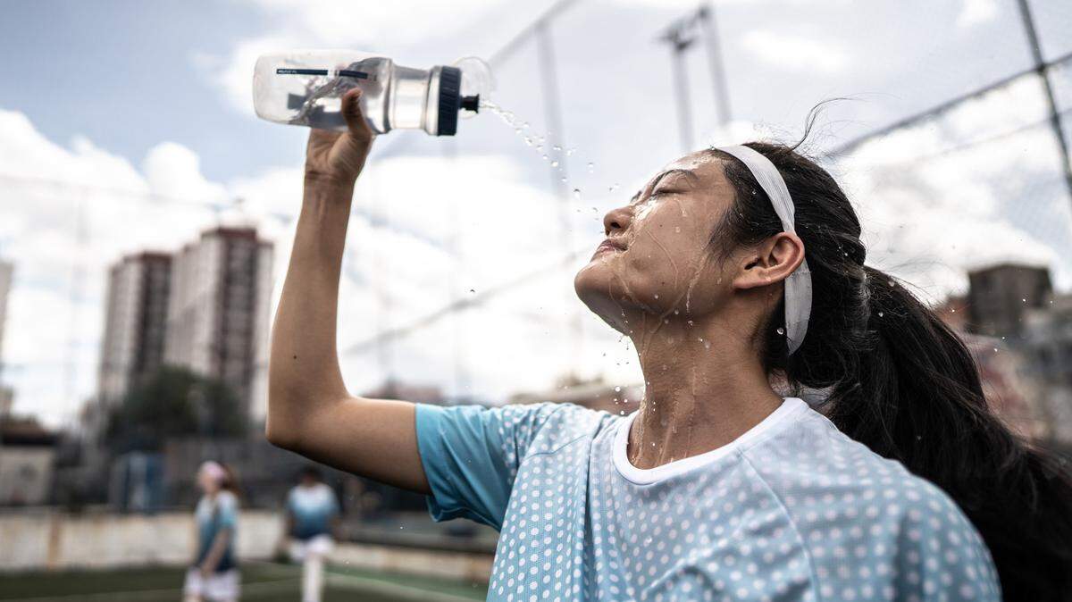 Female soccer player washing face in the field