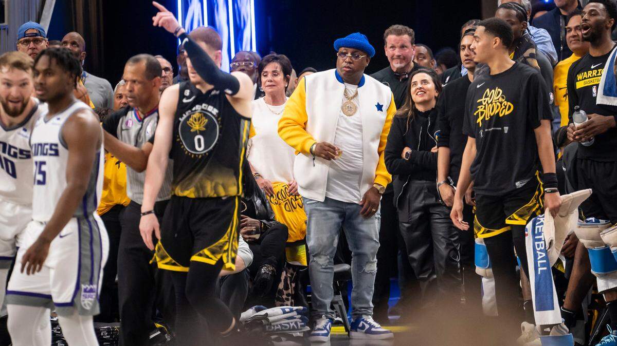 Rapper Earl “E-40” Stevens, center, roots for the Golden State Warriors against the Sacramento Kings in the second half of Game 3 of the first-round NBA playoff series at Chase Center in San Francisco on Thursday.