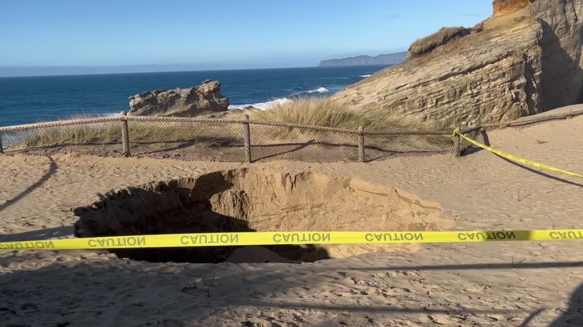 A sinkhole was spotted forming along a cliffside at Cape Kiwanda State Natural Area, near Pacific City, Oregon, on Jan. 22, 2023, park officials said. It has been taped off from the public.