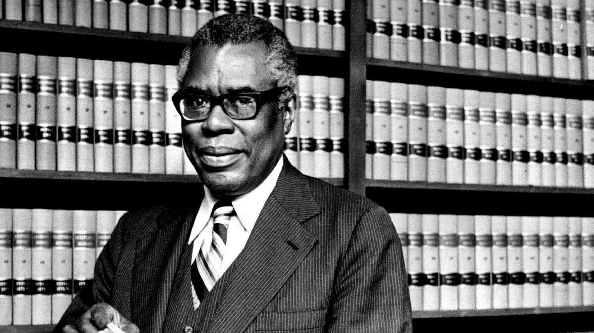 Nathaniel Colley, the first Black attorney to have a private practice in Sacramento, stands in his law library in 1979.