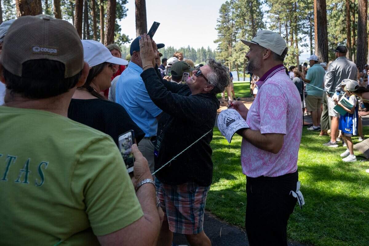 Comedian Nate Bargatze has his photograph taken with a fan during the American Century Championship celebrity golf tournament at Edgewood Tahoe Resort in Stateline, Nev., on Friday, July 11, 2025.
