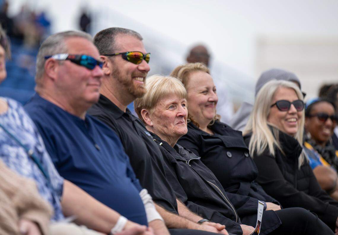 Mary Alberghini, center, listens to stories told of her late husband, former football coach Mike Alberghini, at Grant High School with her family as the Del Paso Heights community celebrated his life of on Saturday. Alberghini passed away in February.