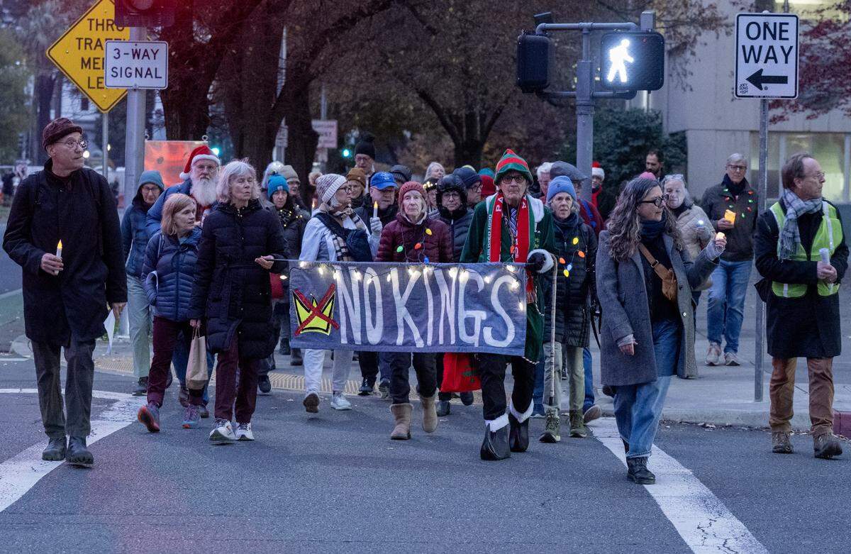 Participants march down Capitol Mall during the “See the Light, Hear Our Voice” candlelight procession in Sacramento on Thursday. Local activists say they are standing for the rule of law and opposing what they describe as cruelty and corruption within the current federal administration.