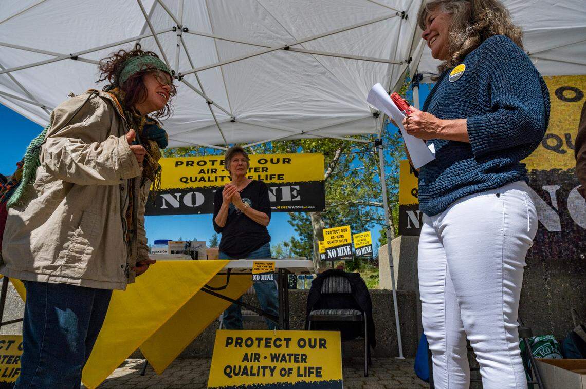 Idaho-Maryland Mine opponents Nicole Lazio, left, Kathy Ogburn, center, and Tracie Sheehan converse in one of the opposition tents set up outside the Nevada County administration center on May 11 for the second day of planning commission hearings on the project.