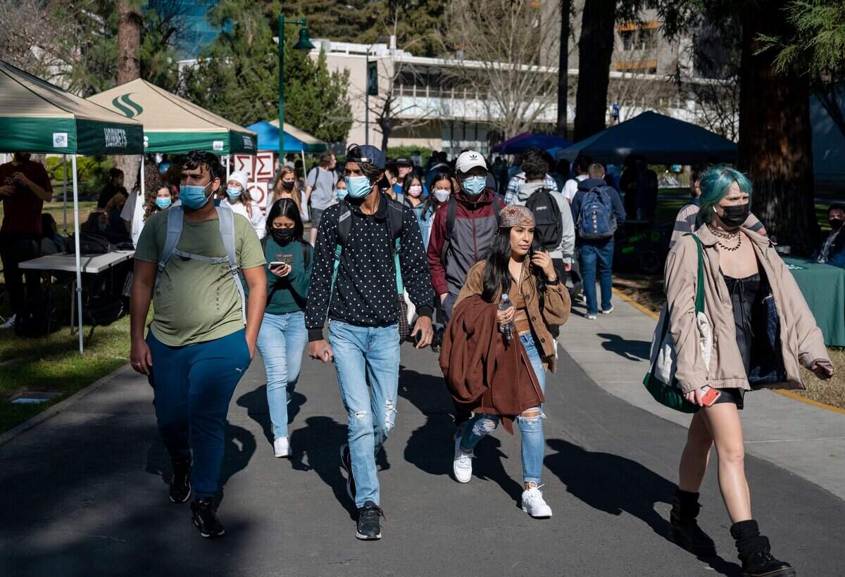 Students walk along the Sacramento State quad outside the library as they return for the first day of in-person learning on Monday, Feb. 7, 2022. Classes since winter break were held online due to the omicron COVID-19 surge, according to a statement on the school’s website.