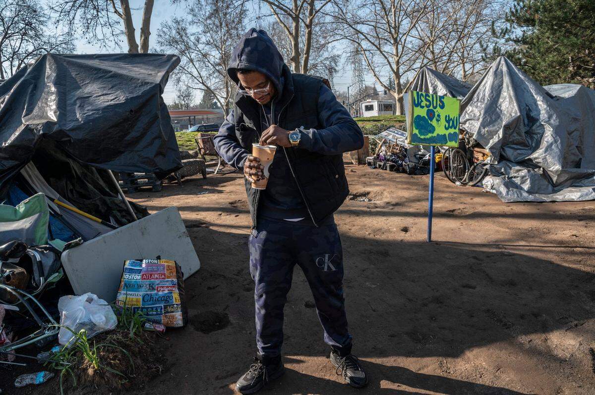 Terence King, 37, stirs oatmeal inside a homeless encampment Friday near the corner of Fair Oaks Boulevard and Howe Avenue where he’s lived for the past two months. “I don’t know where I would go,” said King if he was evicted.