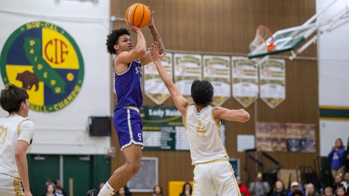 The Sacramento Dragons’ Sir Marius Jones (2) scores a 3-point shot over the Rio Americano Raiders’ Adrian Devenecia (4) in the first half of a CIF Sac-Joaquin Section boys basketball playoff game Wednesday in Sacramento.