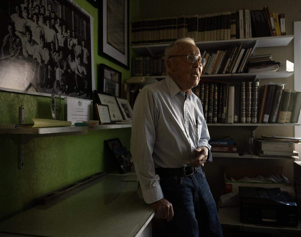 Jim Tanimoto, 102, the last surviving member of the Block 42 resistors, stands in front of a historic photograph of the group that hangs in his home in Gridley earlier this month. The men were transferred to the Tule Lake internment camp for refusing to answer a “loyalty questionnaire” that implied they had maintained allegiance to Japan.