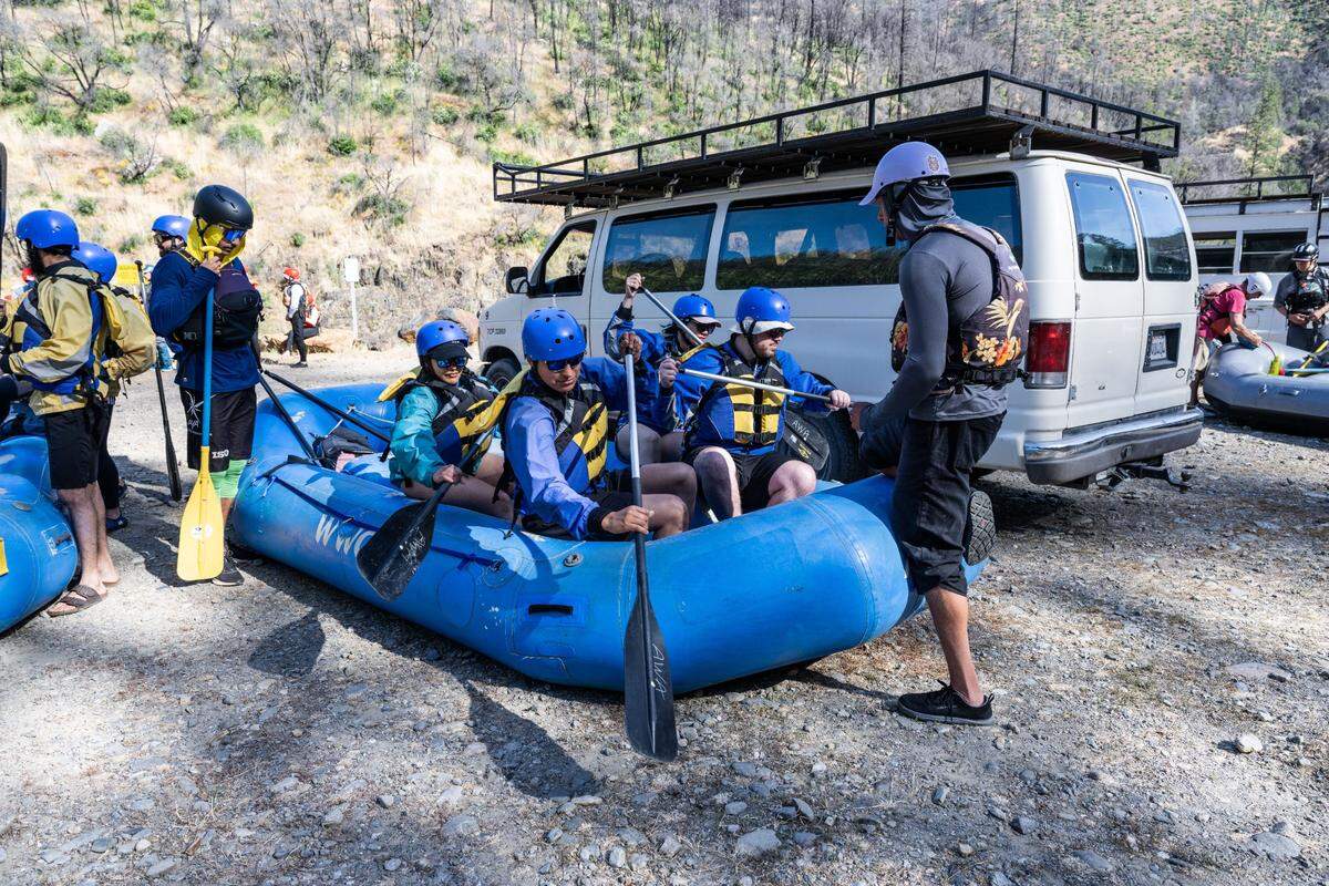 Sam Almeida, right, a guide with Action Whitewater, has his passengers practice rowing their raft at the Oxbow put-in site on the Middle Fork of the American River on Sunday.