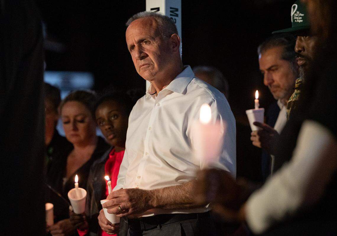 Sacramento Mayor Darrell Steinberg, left, and community activist Berry Accius, founder of Sacramentos Voice of the Youth mentorship program, and other community members hold a vigil at Ali Youssefi Square in Sacramento in April 2022, for victims of a mass shooting in downtown Sacramento. The shooting left six people dead and twelve injured.