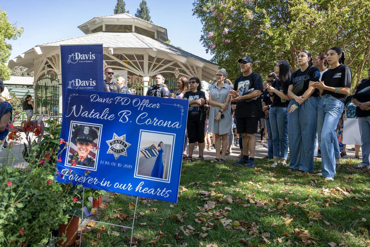 The Corona family listens during a ceremony for the opening of Natalie’s Corner Splash Pad on Saturday at Central Park in Davis. The interactive water feature honors Natalie Corona, the Davis police officer killed in the line of duty in 2019.