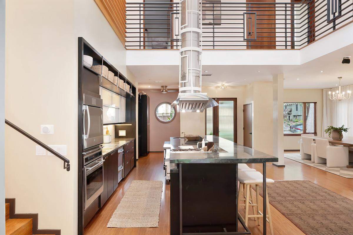 The chef’s kitchen, open concept and upstairs balcony overlooking the downstairs space marks the Donner Way home for sale.