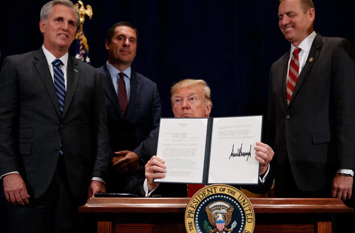 President Donald Trump holds up a “Presidential Memorandum Promoting the Reliable Supply and Delivery of Water in the West,” after signing it during a ceremony, Friday, Oct. 19, 2018, in Scottsdale, Ariz. Standing behind the president from left, Majority Leader Kevin McCarthy, R-Bakersfield, Rep. Devin Nunes, R-Tulare., and then Rep. Jeff Denham, R-Modesto.