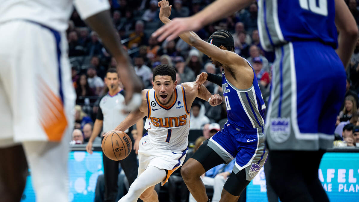Phoenix Suns guard Devin Booker (1) drives to basket against Sacramento Kings forward KZ Okpala (30) during a game at the Golden 1 Center in Sacramento, Monday, Nov. 28, 2022.