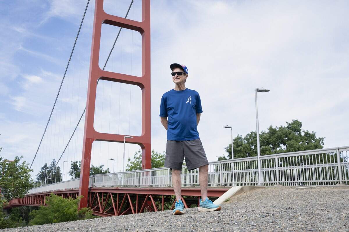 The Sacramento FrontRunners and FrontWalkers founder James Evans-Brown poses for a portrait in front of the Guy West Bridge along the American River Parkway in Sacramento on Saturday.