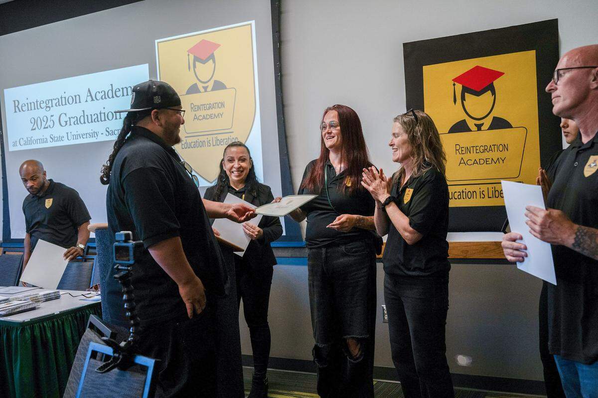Tone Alcantara, left, receives his certificate of completion at the Reintegration Academy graduation at Sacramento State on May 9. Students spent eight weeks in the program, which helps formerly incarcerated individuals reintegrate into society by assisting them in finding jobs or enrolling in college or vocational training.
