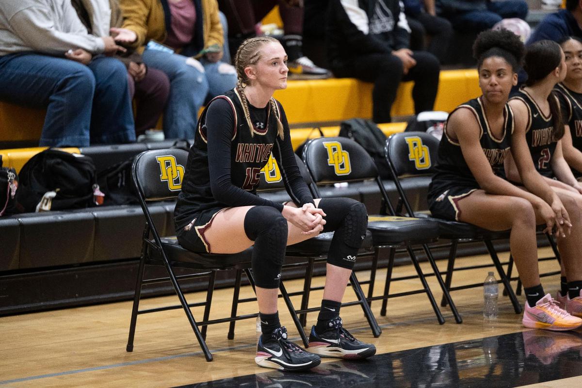 Whitney High School girls basketball star Harper Peterson sits on the bench after being ejected from the game for back talk at Del Oro High School in Loomis on Friday.