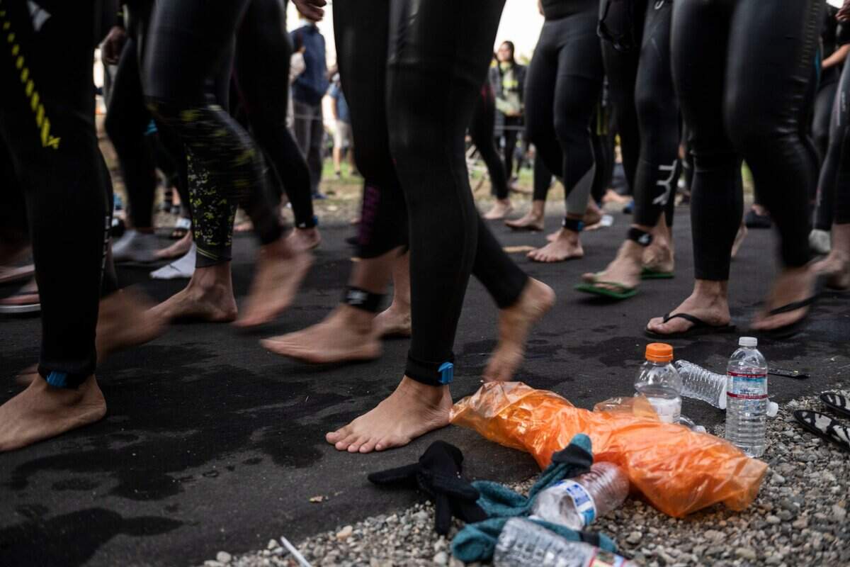 Competitors walk to the starting line for the Ironman California triathlon in Sacramento on Sunday, Oct. 23, 2022.