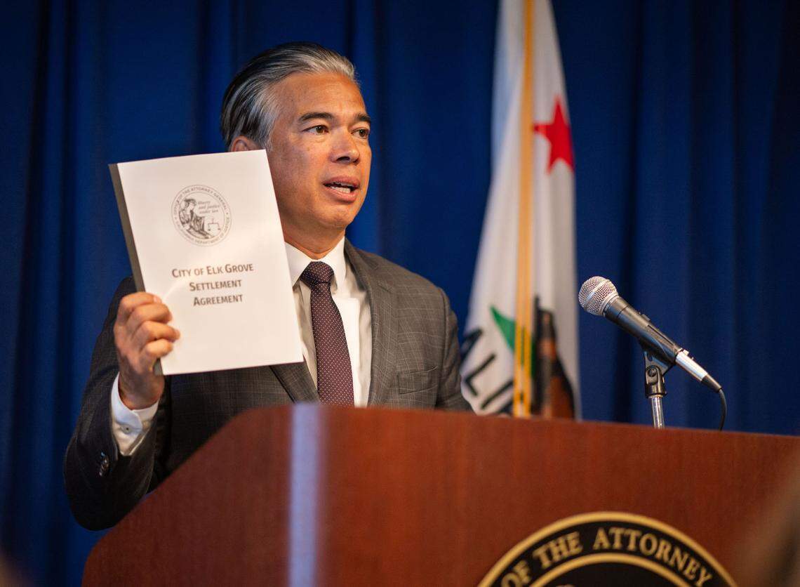 California Attorney General Rob Bonta holds up a housing settlement agreement with the city of Elk Grove at a 2024 California Department of Justice press conference in Sacramento.