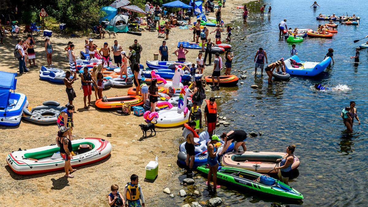 American River visitors gather near the shore to get into boats, rafts and other inflatables in the Sunrise Recreation Area near Rancho Cordova during Memorial Day weekend on Sunday, May 24, 2020.