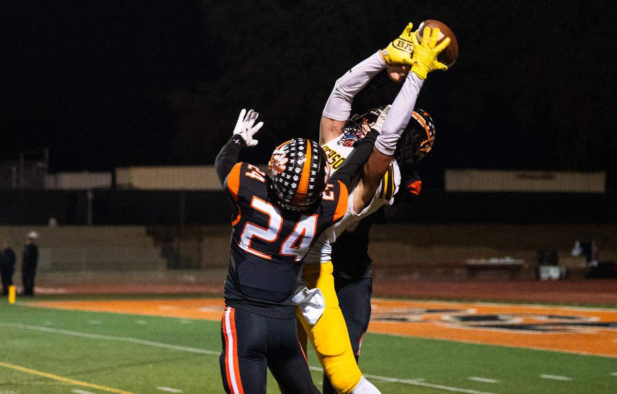 Hughson Huskies tight end Titus Beers (23) grabs a deep pass off a flea flicker amid double coverage by the Roseville Tigers in a CIF Sac-Joaquin Section Division IV semifinal in Roseville on Friday, Nov. 21, 2025.
