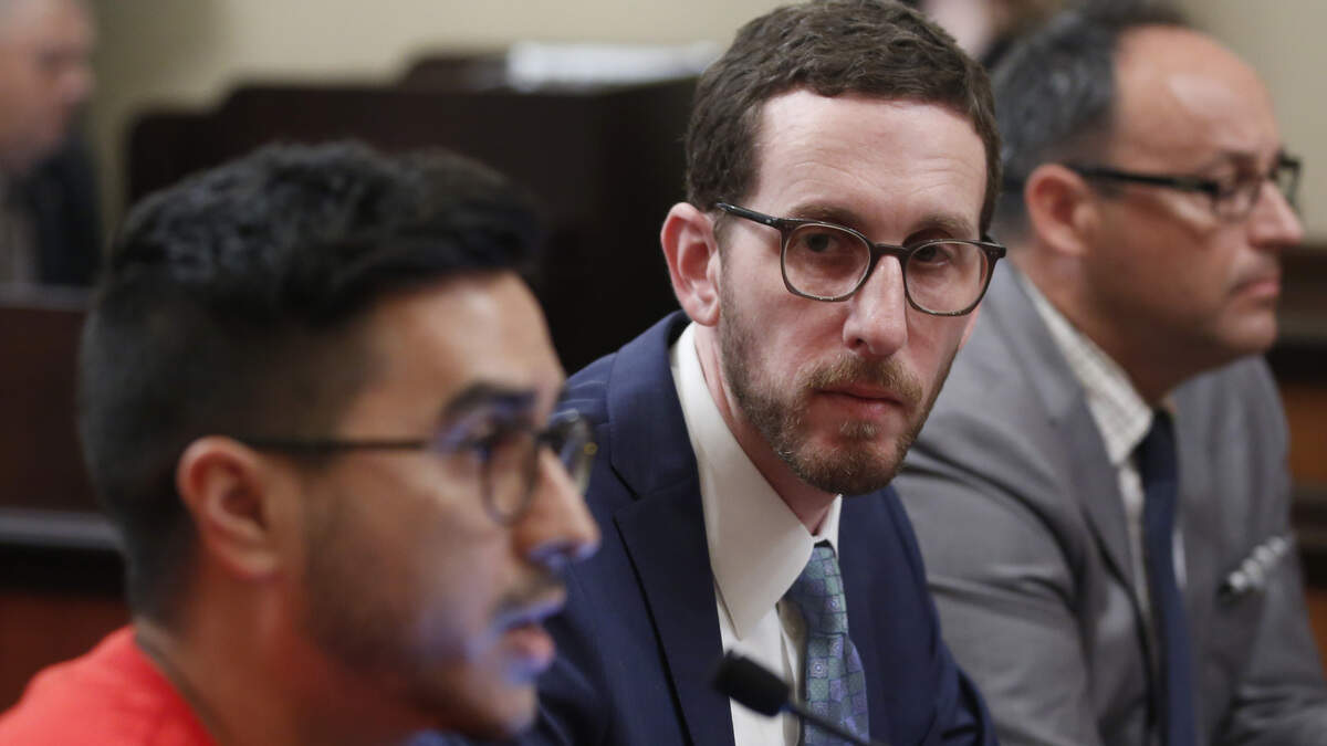 State Sen. Scott Wiener, D-San Francisco, center, listens as Rene Moya, left, director of Housing Is A Human Right, testifies against Wiener’s housing measure Wednesday, April 24, 2019, in Sacramento, Calif. Wiener’s bill, SB50, that would increase housing near transportation and job hubs was approved by the Senate Governance and Finance Committee, after it was merged with SB4, a measure by State Sen. Mike McGuire, D-Healdsburg.