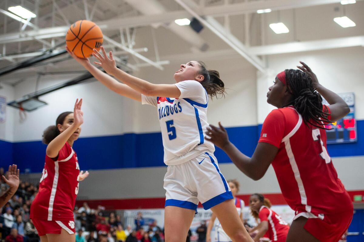 Folsom Bulldogs guard Ella Uriarte (5) drives to the basket between McClatchy Lions Norret Lewis (3) and center Milah Masters (33) in the second half in the semifinals of the CIF Sac-Joaquin Section Division I girls playoff game on Tuesday, Feb. 21, 2023, at Folsom High School in Folsom. The Bulldogs won 57-52.