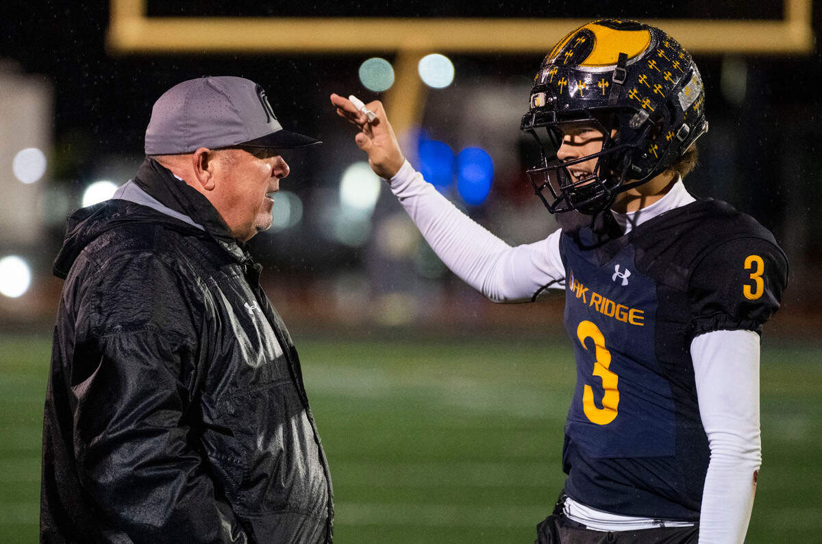 Oak Ridge Trojans coach Casey Taylor speaks with quarterback Joaquin Graves-Mercado (3) on the sidelines in the fourth quarter against the Turlock Bulldogs  in a Sac-Joaquin Section semifinal playoff game on Friday, Nov. 22, 2024, in El Dorado Hills. 