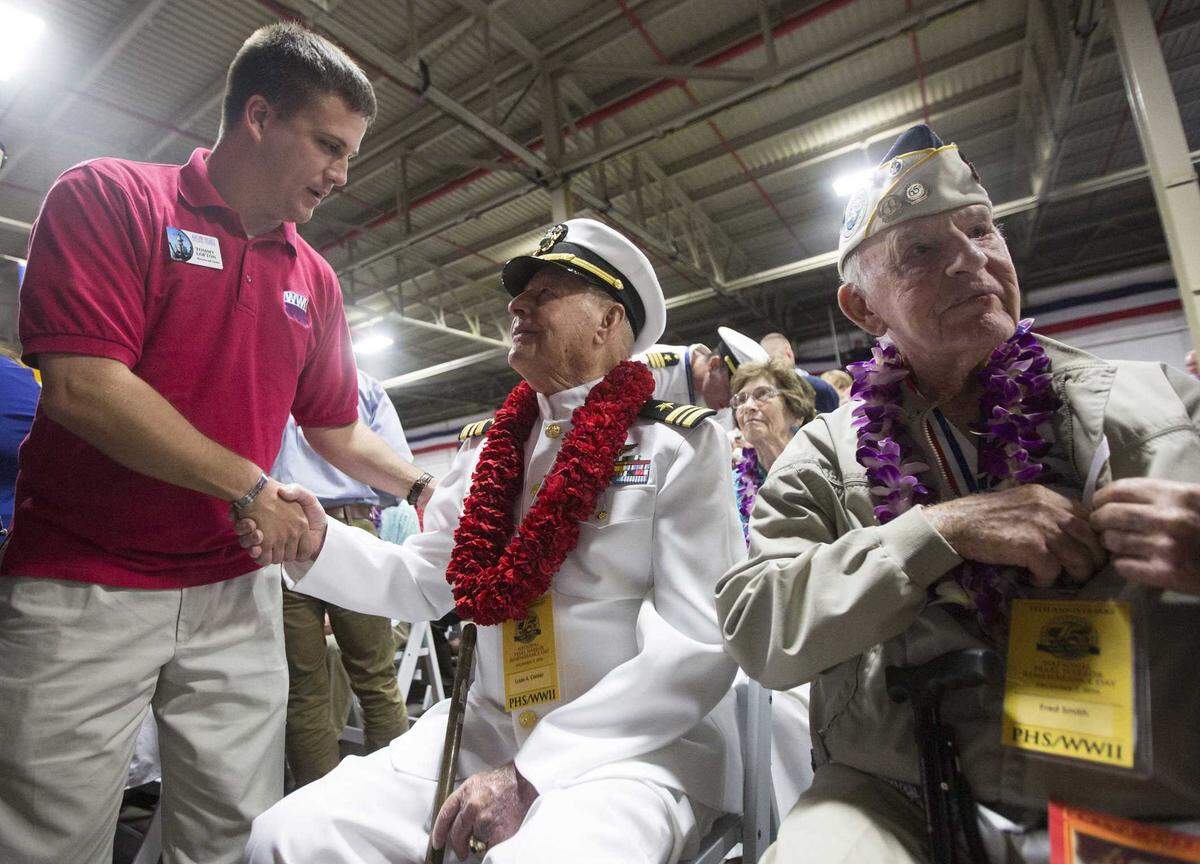 Tommy Lofton shakes hands with USS Arizona survivor Lou Conter, center, before the start of the 75th annual remembrance of the attack on Pearl Harbor in Hawaii. Conter, the last survivor of the attack by the Japanese on the USS Arizona, died Monday at the age of 102, surrounded by family in Grass Valley.