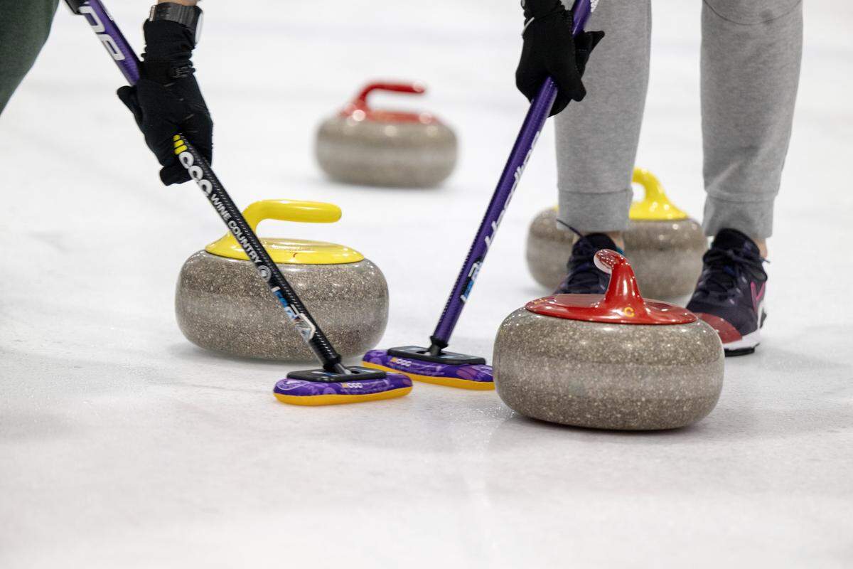 Curling participants sweep in front of a curling stone before it stops earlier this month at Skatetown Ice Arena in Roseville.