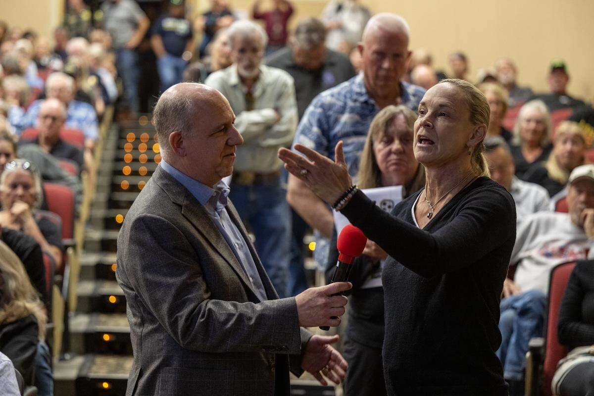 Paul Hellman holds the microphone as Holli Tamas asks a question about the profit the builder will make on the proposed Hope Way Apartments in Penryn during a community meeting about the project on Wednesday, Oct. 1, 2025, at Del Oro High School.