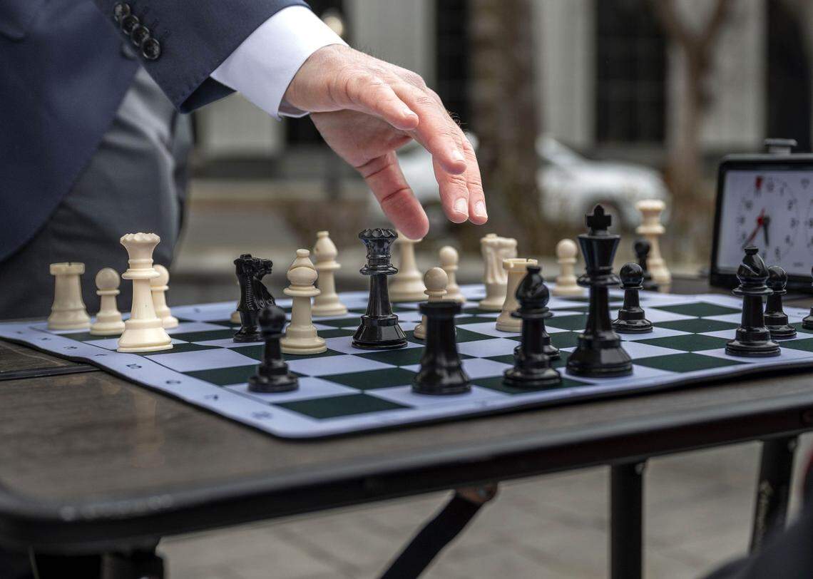Patrick Wolff, a candidate for California Insurance Commissioner, makes a move as he plays chess at Capitol Park on Tuesday, Jan. 20, 2026. Wolff has been traveling the state challenging the public to beat him — he will pay their home insurance for one month if they win.