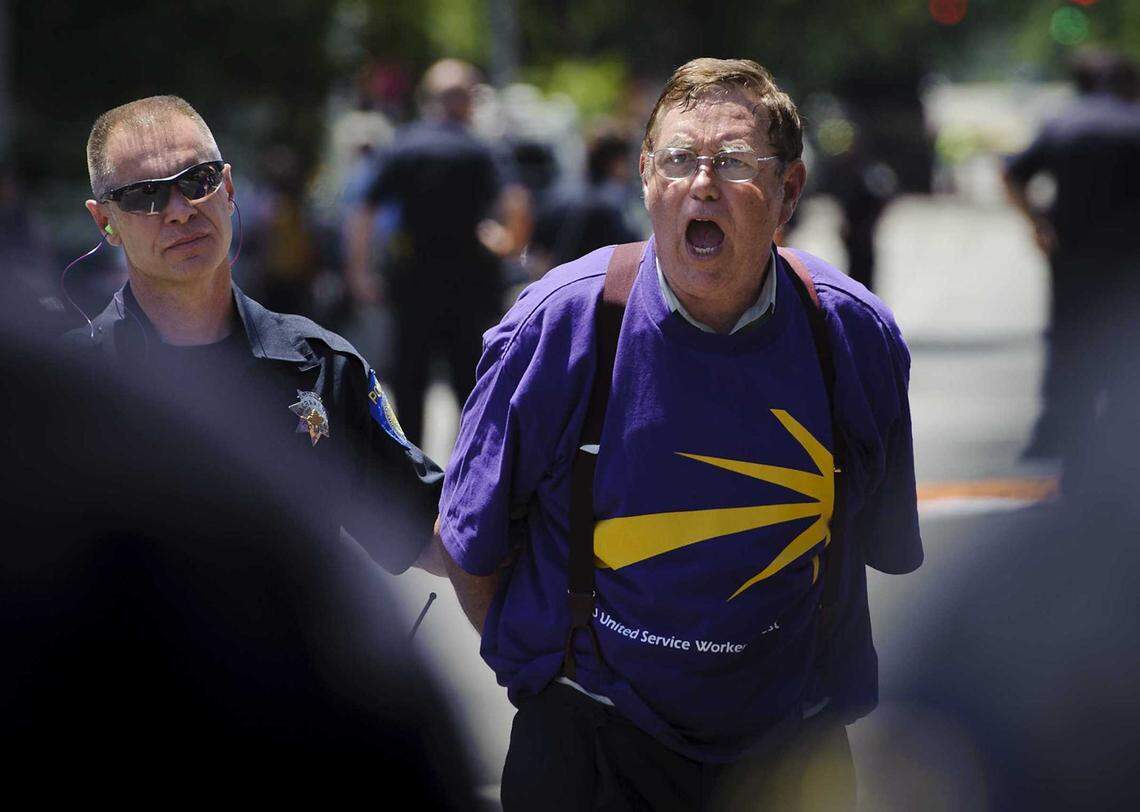Bill Camp, executive secretary of the Sacramento Labor Council, is arrested by Sacramento police in 2012 after blocking Third Street and Capitol Avenue during a protest by janitors represented by the Service Employees International Union protesting demands by office employers that they accept contract concessions. Camp, the labor council’s longtime leader, died Sept. 23 at the age of 80.