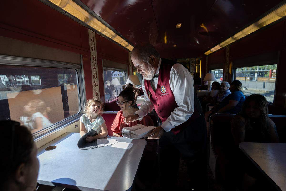 Steward Steve Wilson passes out napkins in a passenger car Saturday as the California State Railroad Museum’s historic Granite Rock 10 steam locomotive pulled an excursion train in Old Sacramento for the first time since 2019.