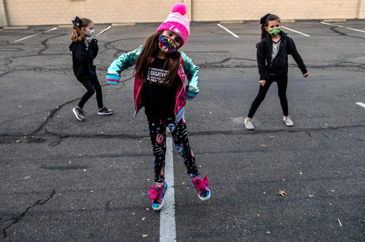 Elena Medley, 7, shows off her dance moves during a petite crew hip-hop class for second graders in the parking lot of the Leighton Dance Project in Folsom on Thursday, Jan. 7, 2021, during the coronavirus pandemic. The dance studio has been teaching classes outside. Students can join via Zoom from home or they can take a class with teachers via Zoom inside the studio.