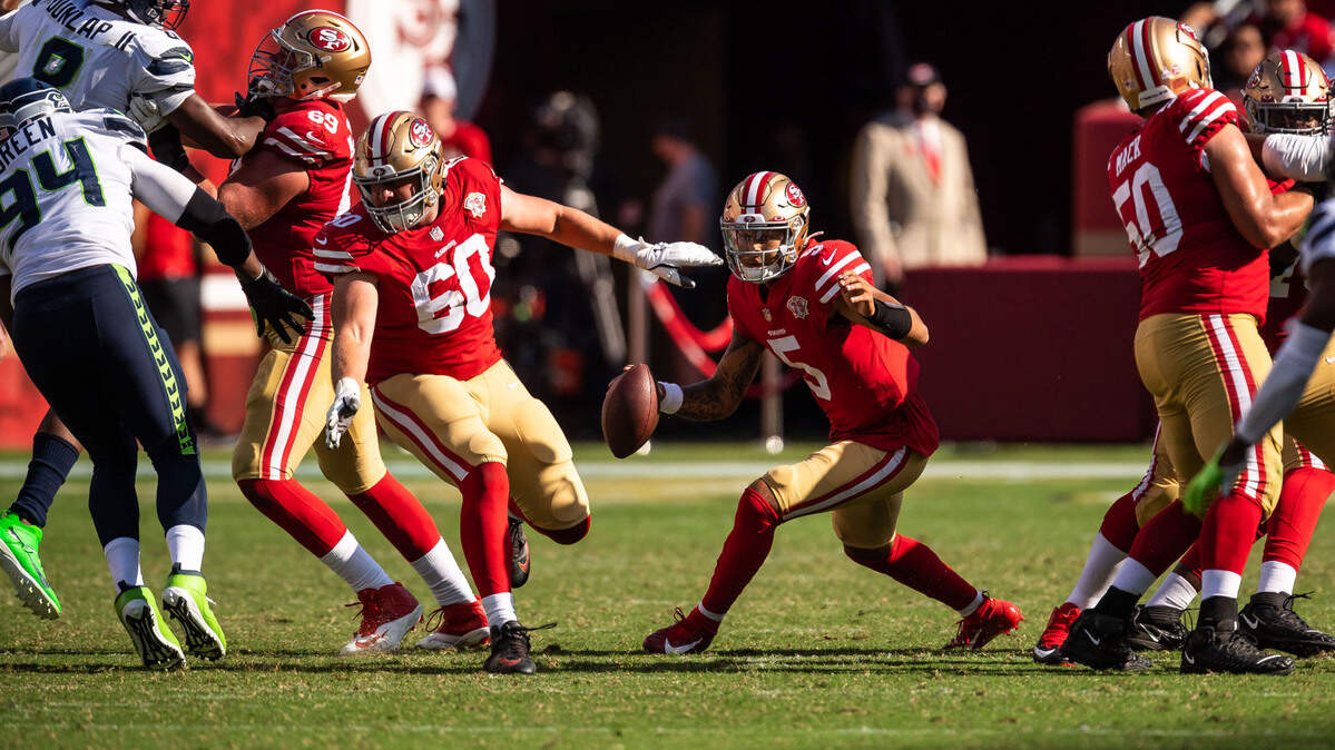 San Francisco 49ers quarterback Trey Lance (5), center, scrambles on a play in the fourth quarter as teammates, from left, Mike McGlinchey, Daniel Brunskill and Alex Mack protect him from Seattle Seahawks during the fourth quarter of the NFL football game Sunday, Oct. 3, 2021, at Levi’s Stadium in Santa Clara. The Seahawks beat the 49ers 28-21.