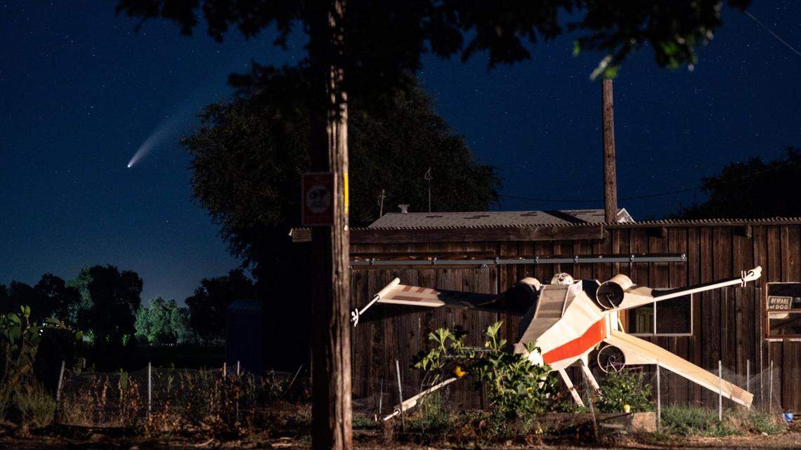 Comet Neowise streaks across the northwestern sky shortly after sunset Tuesday, July 14, 2020, seen past a wooden replica X-wing fighter from “Star Wars” in Jayson and Jennifer Lamoree’s garden near Woodland in Yolo County.