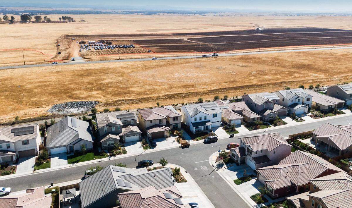 Rancho Cordova homes stand in the foreground as the ground breaking of Braden, a new planned community in Sacramento County, takes place Thursday, Sept. 26, 2024. The 2,667-acre development will include more than 8,000 homes after completion.
