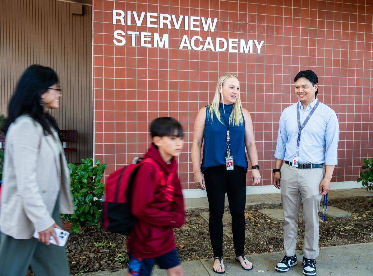 Fourth grade teachers Matthew Chan, right, and Stephanie Lockhart, second from right, greet students and parents on the first day of school at Riverview STEM Academy on Thursday, Aug. 7, 2025.